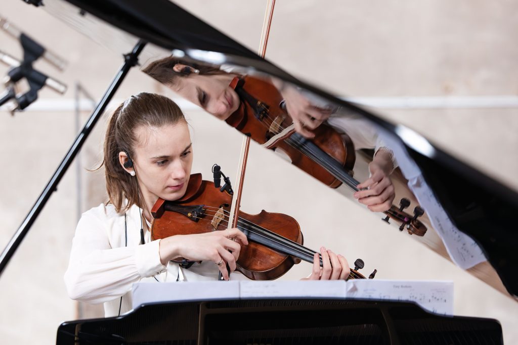 Geigerin spiegelt sich im Flügel – Reportagefotograf Aschaffenburg Konzertaufnahme