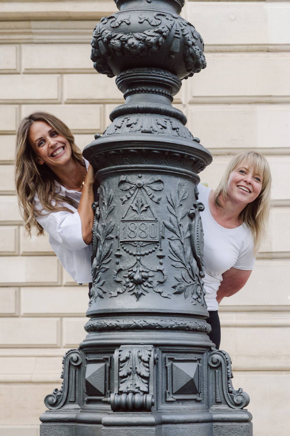 Zwei Frauen lachen hinter antiker Laterne – Fotograf Aschaffenburg Outdoor