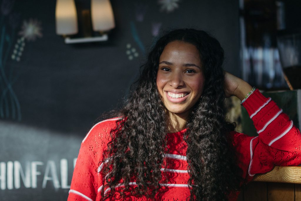 Portraitfotografie Aschaffenburg: lachende Frau im roten Pullover beim Indoor-Portrait
